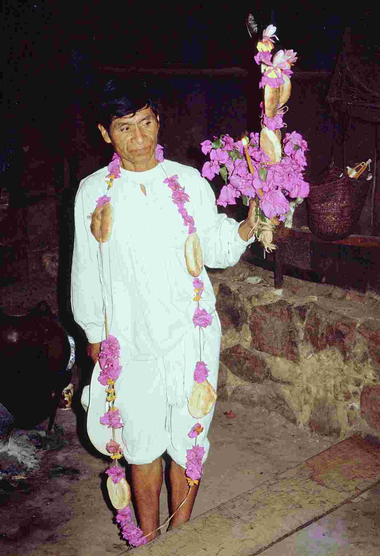 Figure 5.3. Man standing and wearing a xochicozcat and holding a xochicuahuit.