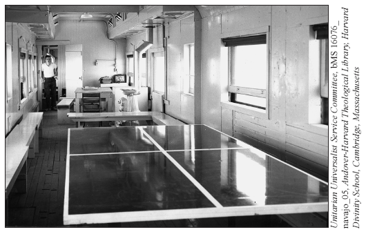 Image: A Santa Fe Railway photo of instructor David M. Brugge standing in front of the door to his quarters in Instruction Car #5007. In the foreground is a ping-pong table for the men. In the center of the car is the instruction area for Brugge’s classes.