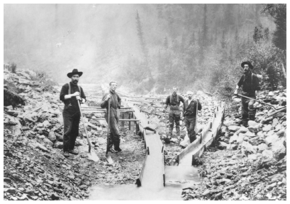 Image: Placer miners on American Creek. Core coll. PCA 01-4508, Alaska State Library. Left to right: Charlie Gay, Libby, Allen, Civil War veteran “Dod” Gardner, Jack Coulter. Pole of telegraph line visible at left ran from Eagle (twelve miles away) to Valdez. The Gold Rush era brought a flood of adventurers, and even small-scale mining operations could create long-term environmental impacts.