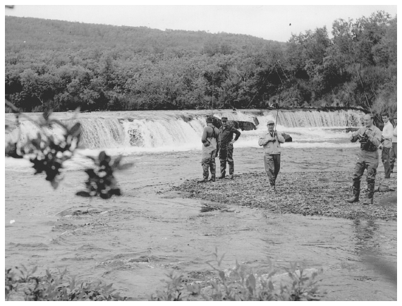 Image: Adlai Stevenson (second from left) and party at Brooks Falls, August 1954. By George Schaller. RG 79G Box 79, National Archives at College Park. Others identified: guide Don Holbrook (left) and John Fell Stevenson (with camera). Controversial fish ladder is out of sight at left. Katmai lost much of its appeal as a scientific curiosity but became famous for fishing and wildlife viewing. Remoteness deterred tourism until the 1950s.