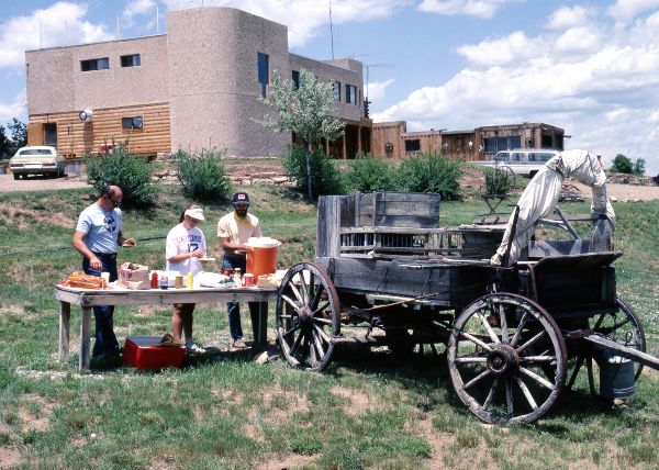 Six people standing and sitting on the Lodge porch at the Crow Canyon Archaeological Center